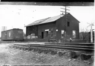 The rail depot beside the tracks, circa 1910