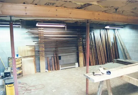 Restored antique boards racked along the basement wall to dry