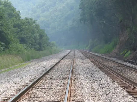 The railroad tracks disappearing into the misty valley