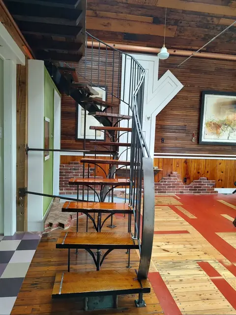 Interior, the curved steel stair with its wood treads and the tree-shaped door, photo 7 of 32