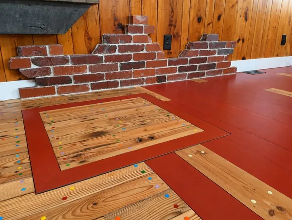 Interior, the brick-faced wall and the red painted floor with its inlaid pine panel and colored dots, photo 24 of 32