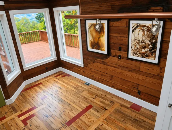 Interior, the corner room with its tall windows over the deck, the paneled walls and the pine floor with red inlays, photo 23 of 32