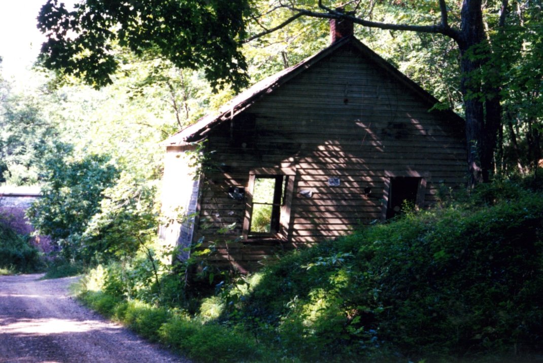 The old building still standing beside the gravel road, before dismantling began.